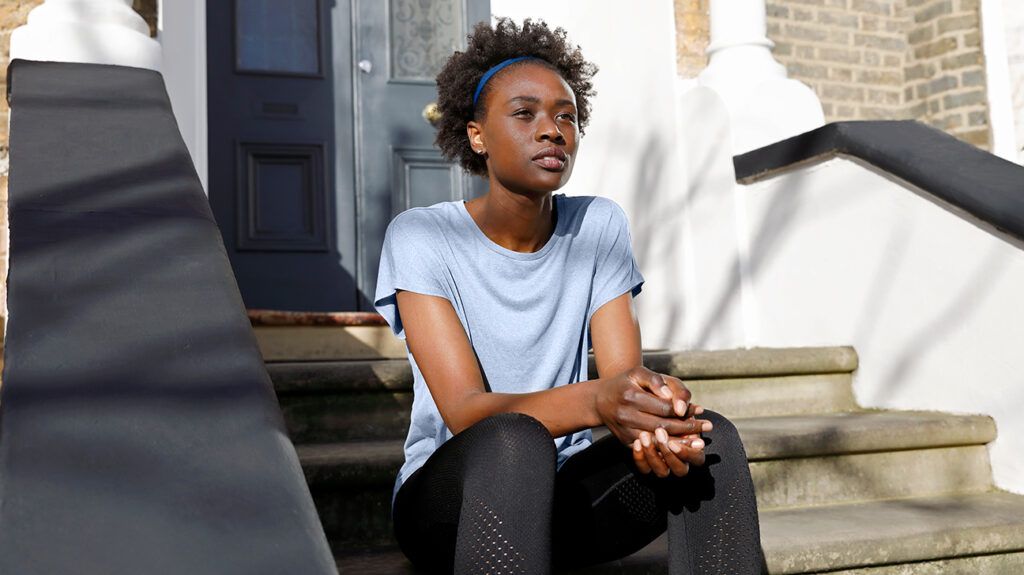 Woman sitting on the stoop, feeling self-pity